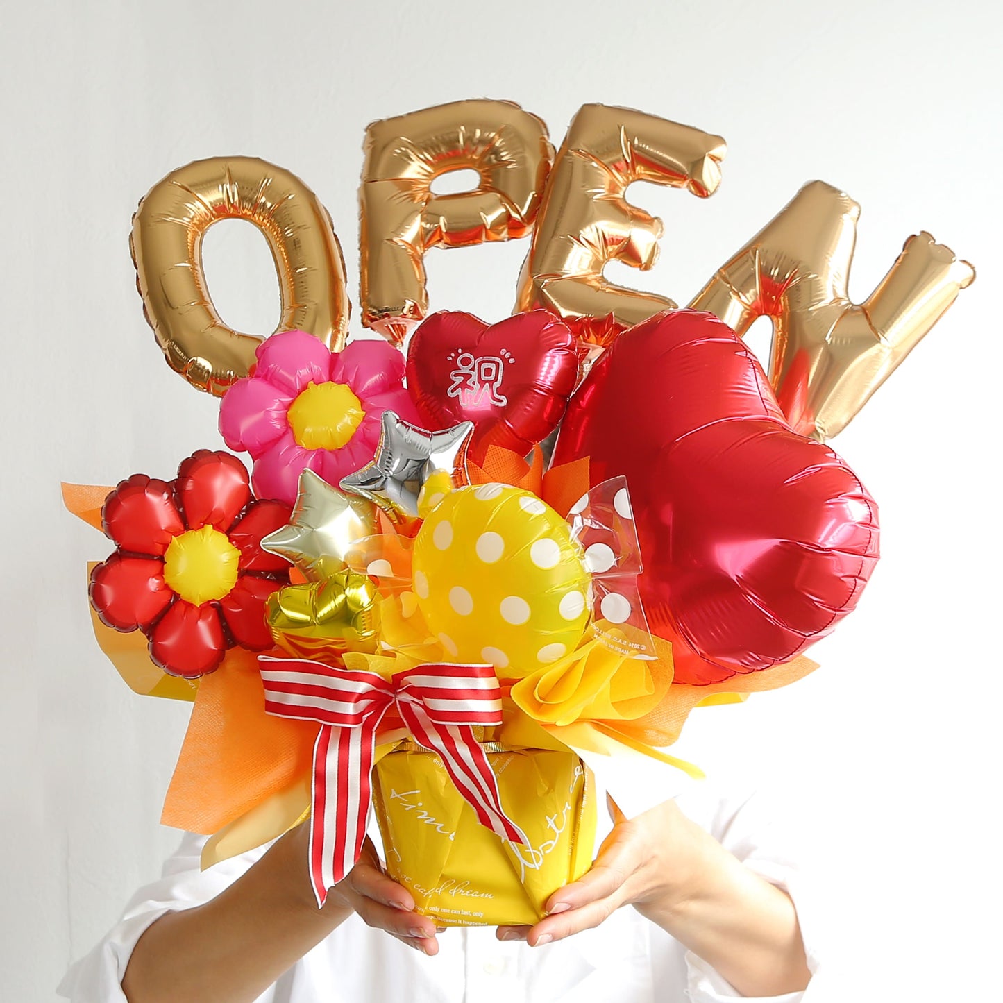 赤いハートと花を使った開店祝い用のバルーンギフトを手に持った写真