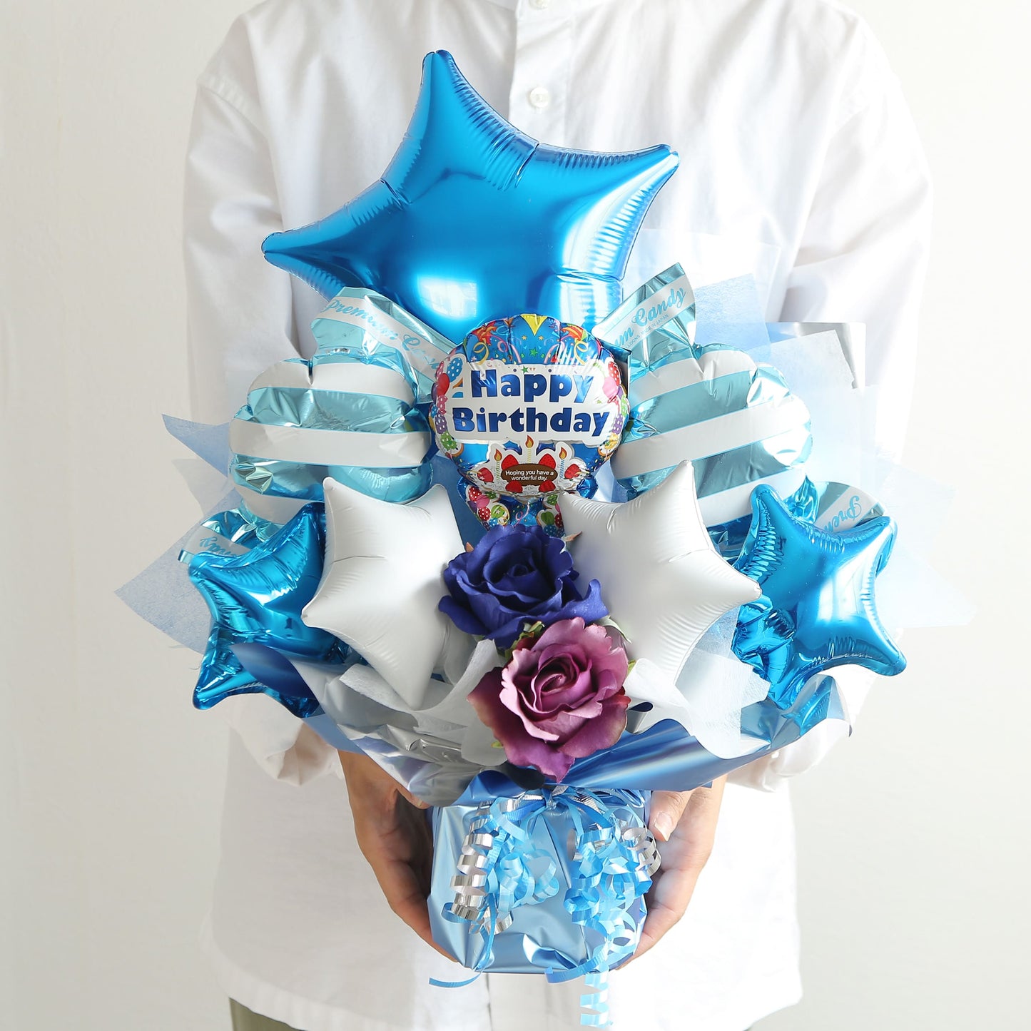 星が入ったブルーの豪華な誕生日用バルーンギフトを手に持った写真